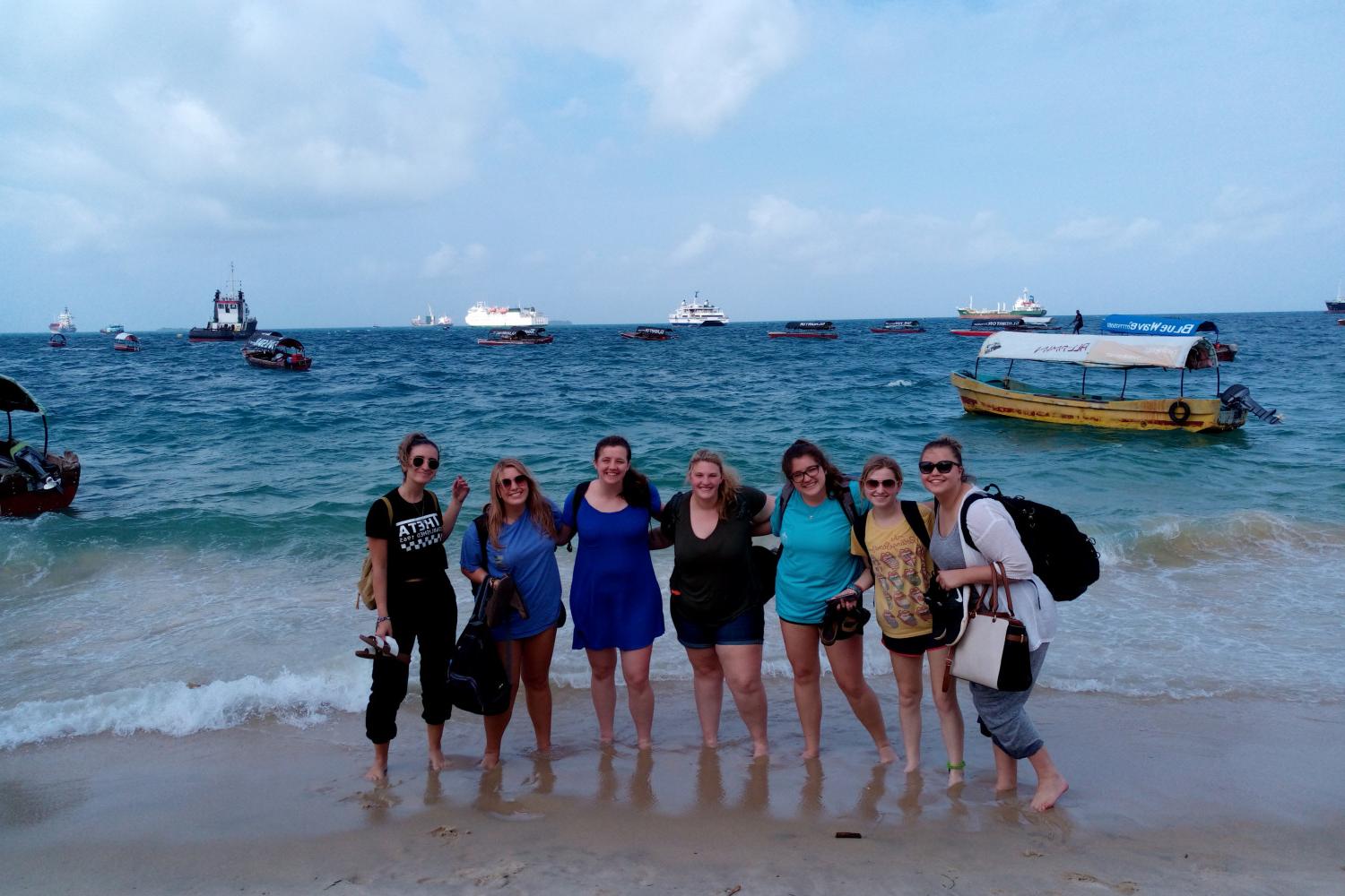 Students pose for a photo seaside on a j项 study tour in 坦桑尼亚.